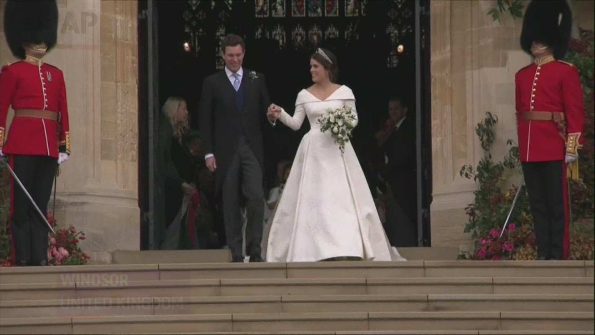 Newlyweds Princess Eugenie and Jack Brooksbank depart St. George's Chapel in carriage through Windsor, as the royal family looks on. (Oct. 12)