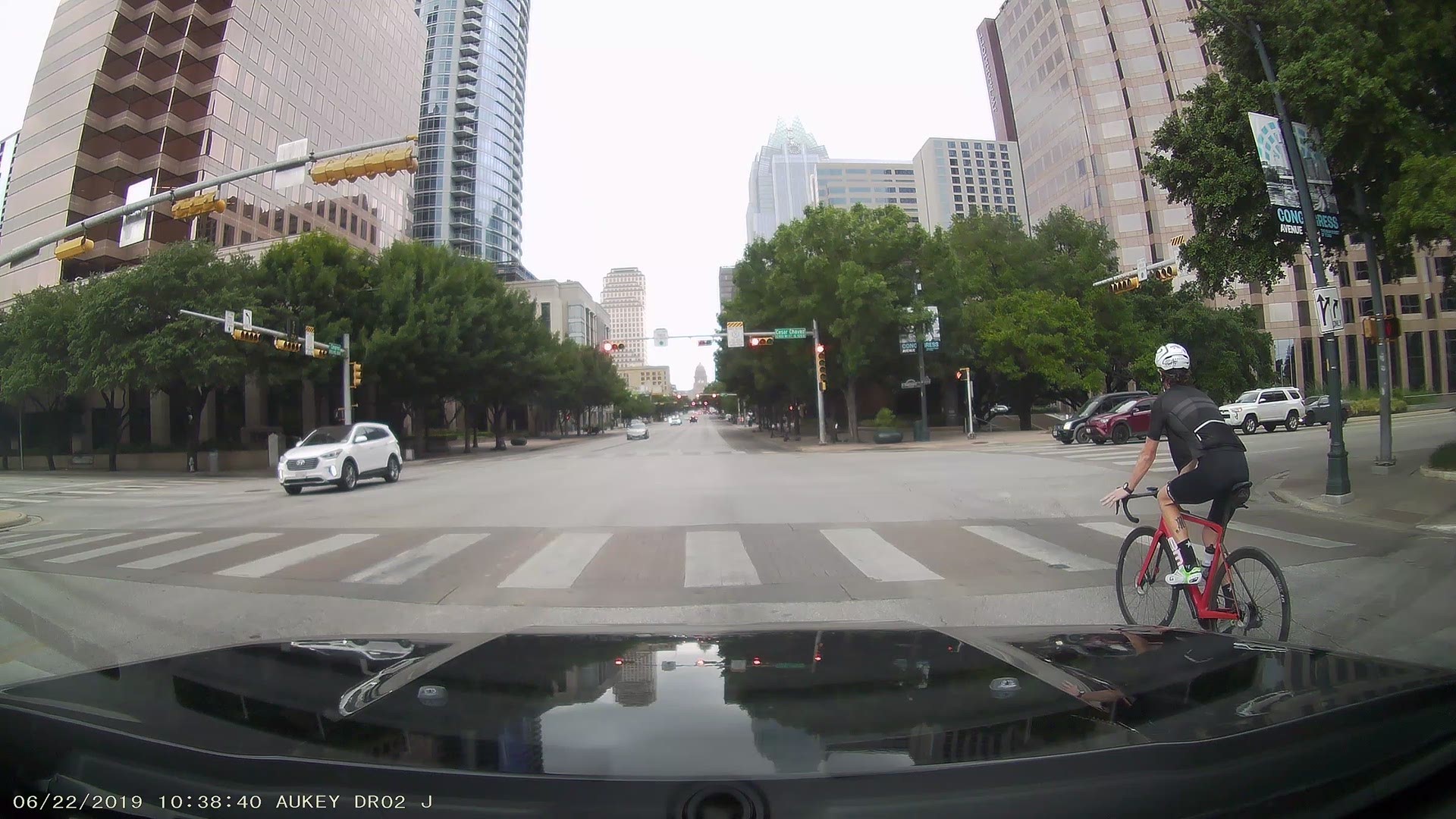 A cyclist can be seen running a red light in Austin while cutting across traffic, breaking multiple traffic laws.