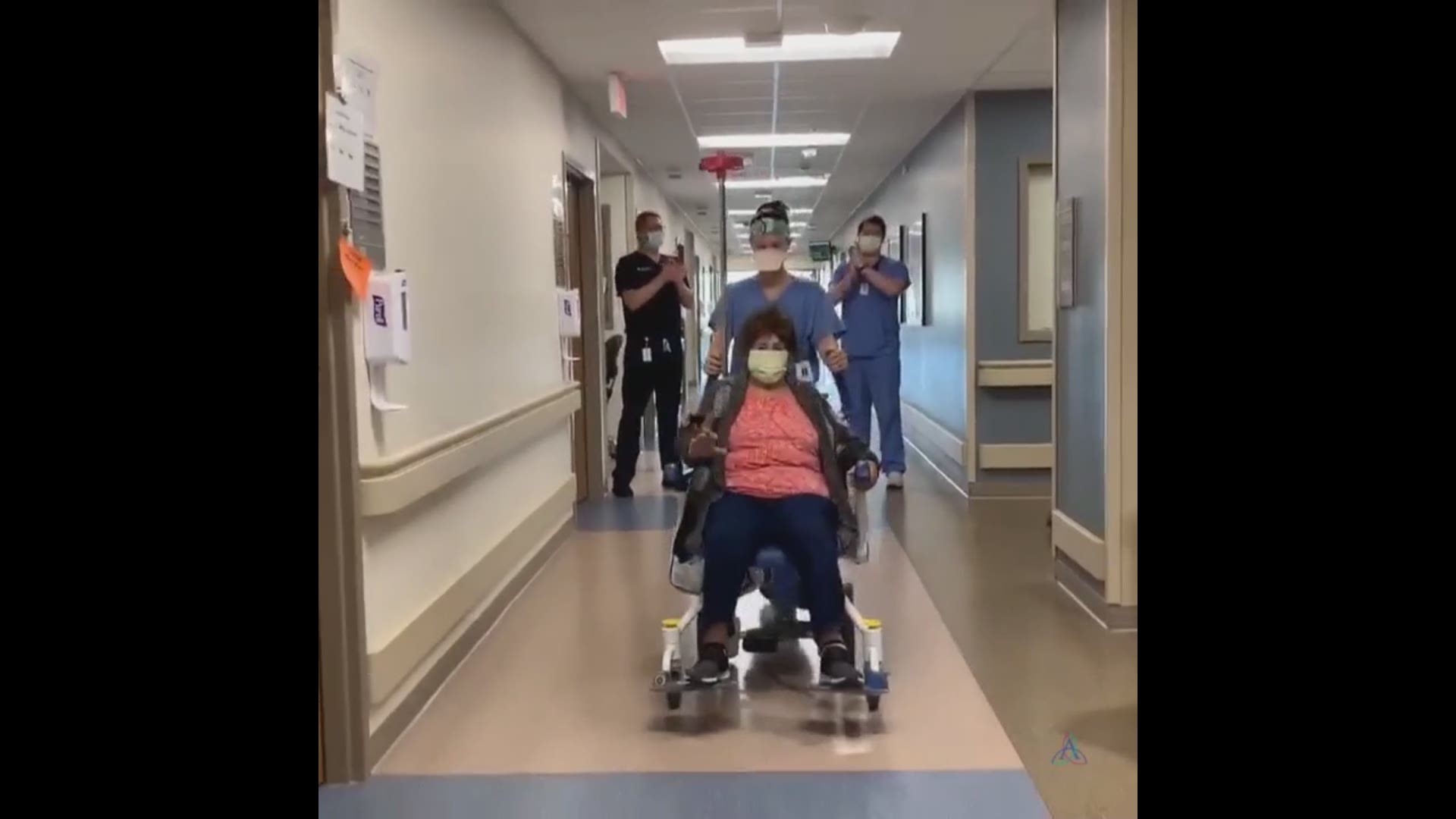 hospital staff cheers on couple leaving hospital