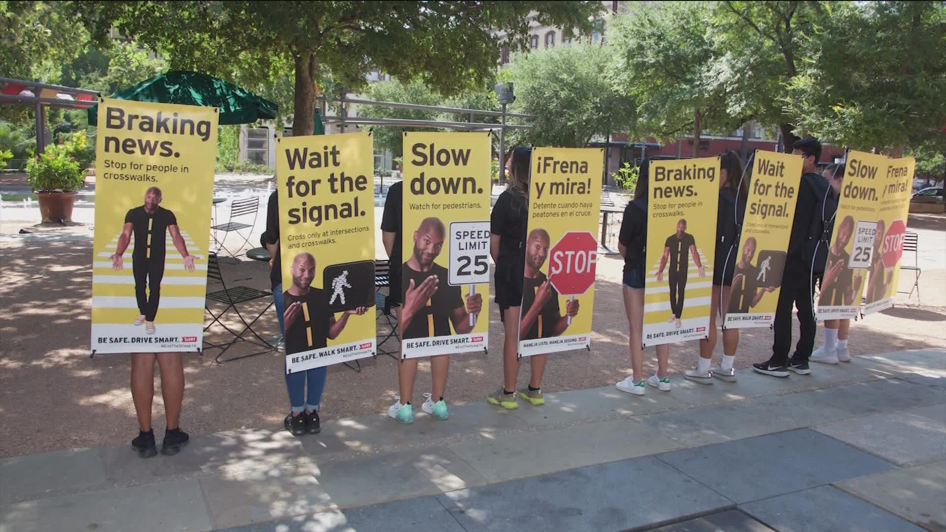 The "human billboards" are TxDOT street team members wearing sandwich boards with messages urging drivers to be mindful of pedestrians.