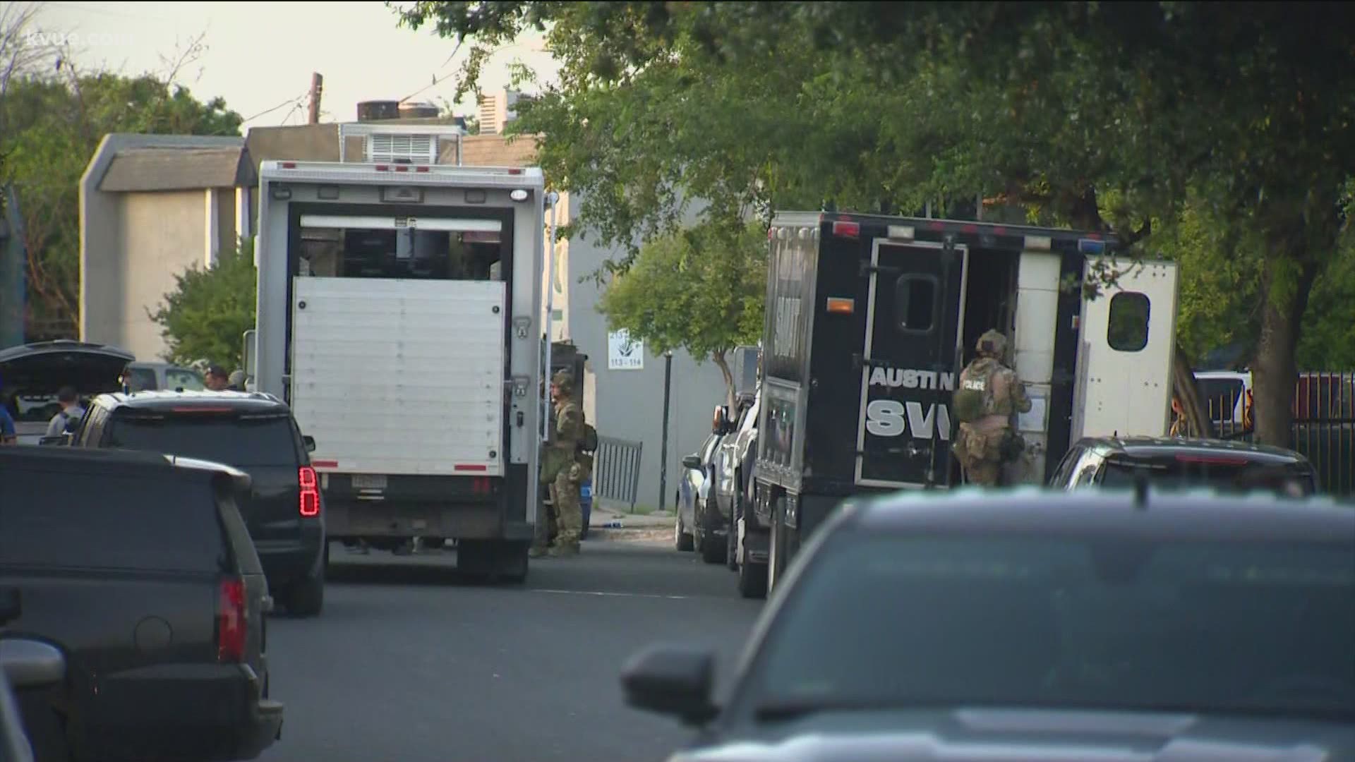 SWAT team members and other officers are trying to arrest two men who have barricaded themselves inside an apartment.