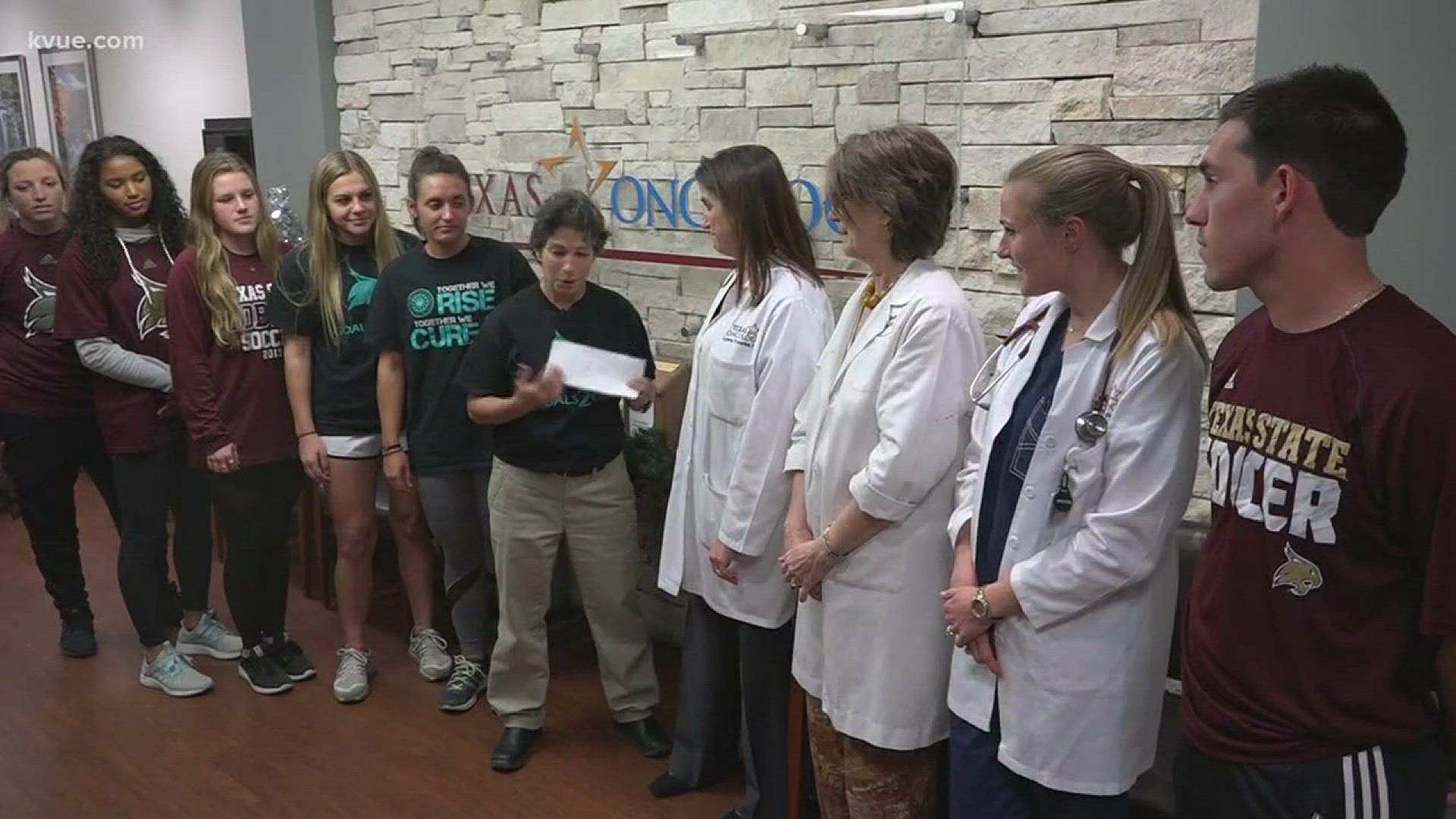 The coach presented a $4,500 check to benefit a Texas Oncology Foundation scholarship.