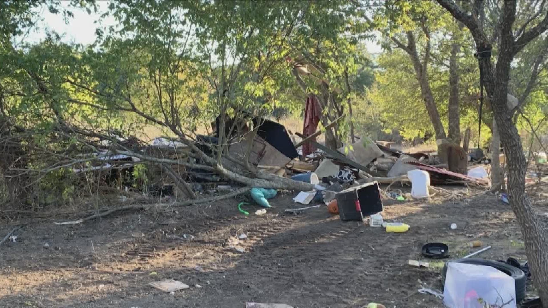 Trash, piles of wood and shopping carts are littering a southeast Austin park.