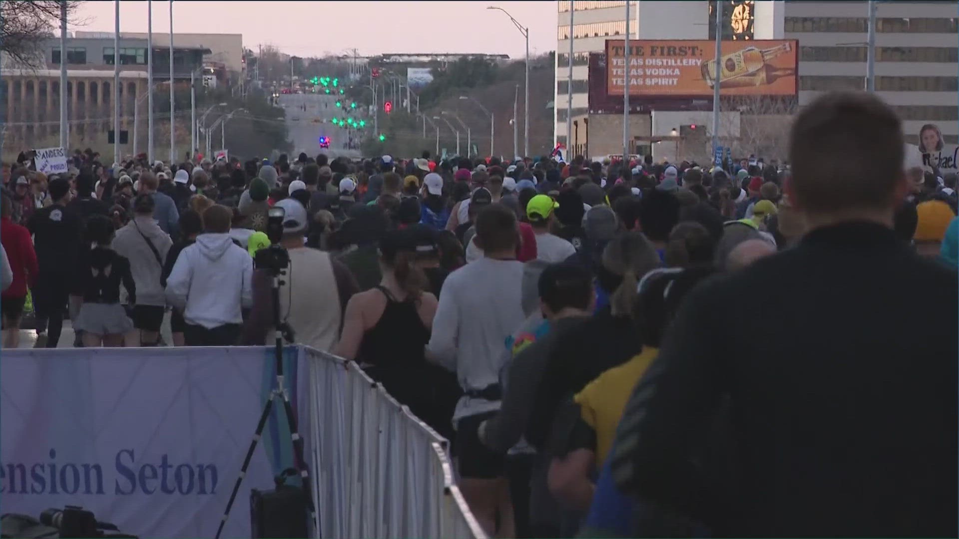 Austin police arrested a man after they say he hit a police car that was blocking the route for runners at the Austin Marathon.